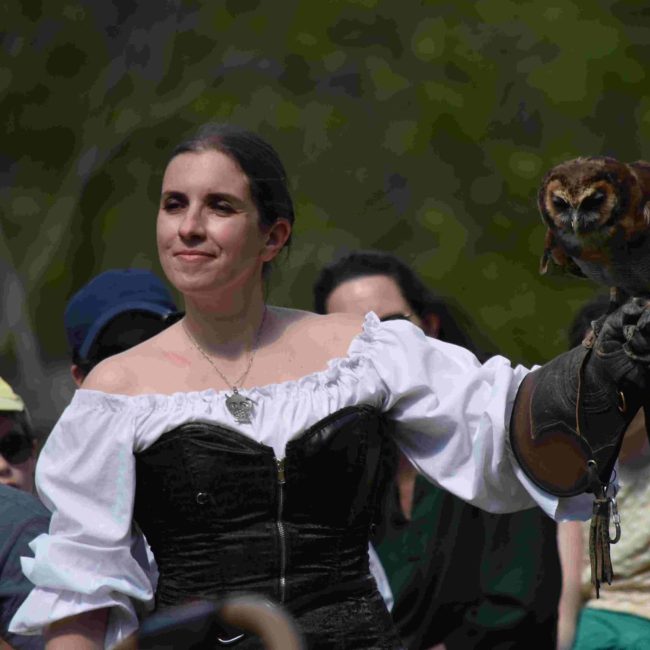 Fauconnier femme en costume médiéval avec une chouette au gant
